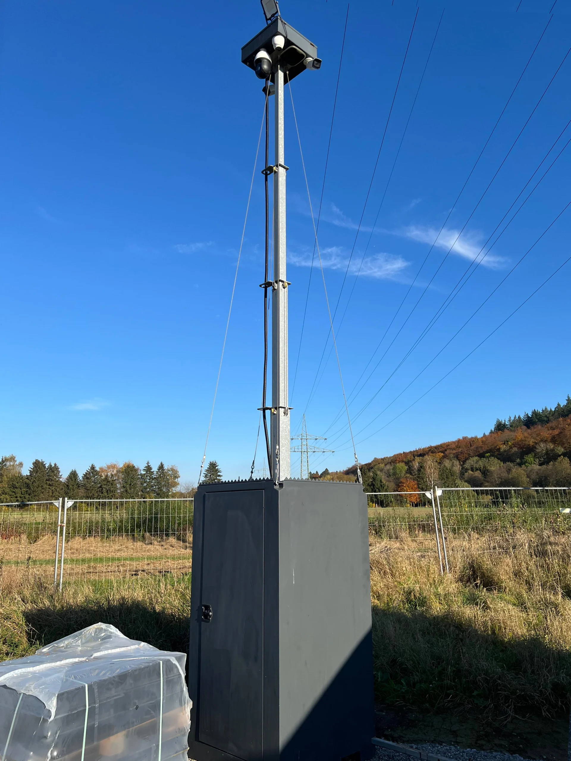 Mobiler Sicherheits-Turm mit Kamera, Solarpanel und robustem Gehäuse in freier Landschaft.